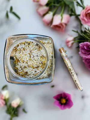 Bath Salts in jar and test tube Floral background on bathroom counter