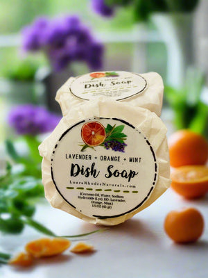 soap kitchen sink in sunny window in kitchen flowers and herbs in background with oranges lavender and mint
